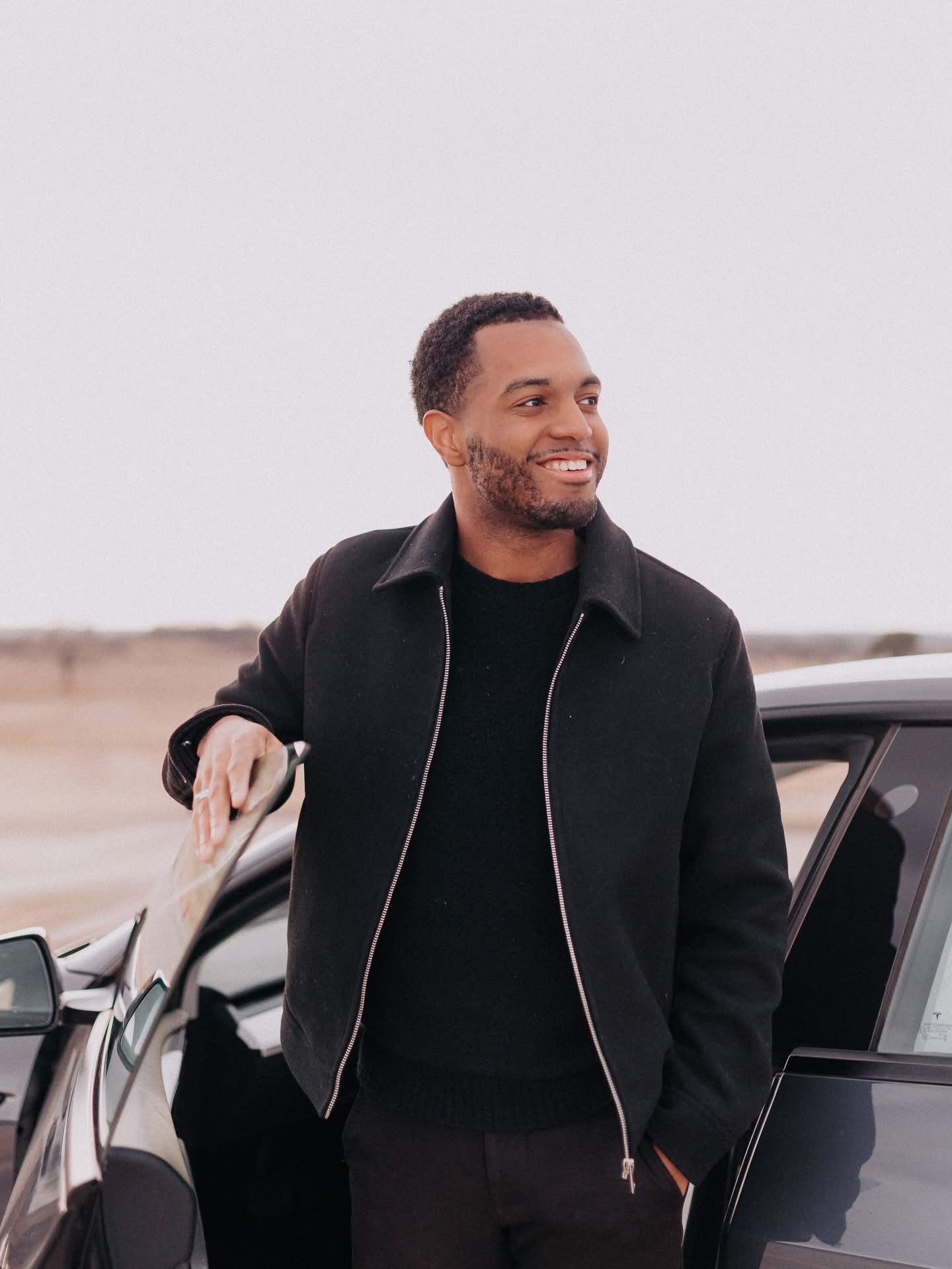 Davon Lee standing beside a car at golden hour